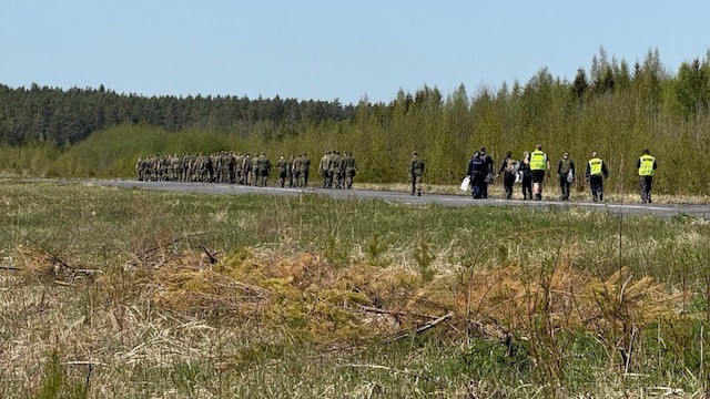 Varusmiehet ja poliiseja sekä onnettomuustutkijoita matkalla onnettomuuspaikalle.